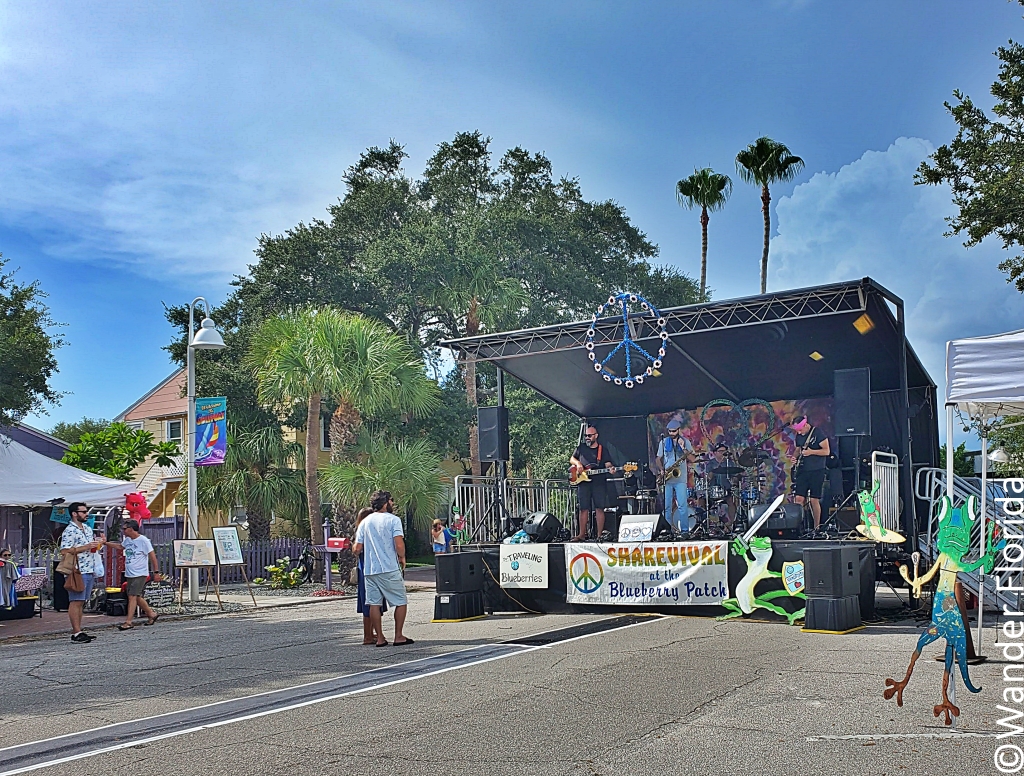 GeckoFest: Gulfport's Epic Way to End the Summer 6 A temporary stage at one of Beach Boulevard with a band banner hanging in front and peace sign at the top.